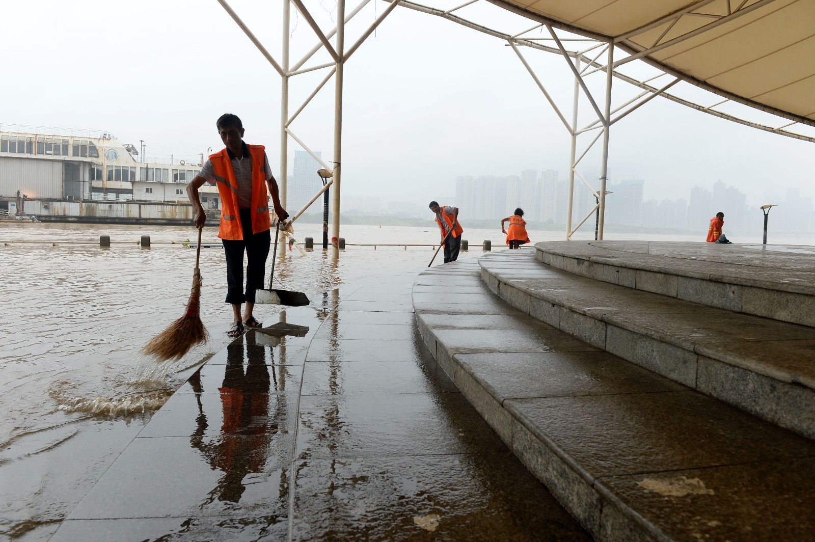7月12日，开福区风帆广场退水1米多，环卫人员进行24小时清淤作业。均为长沙晚报全媒体记者石祯专摄
