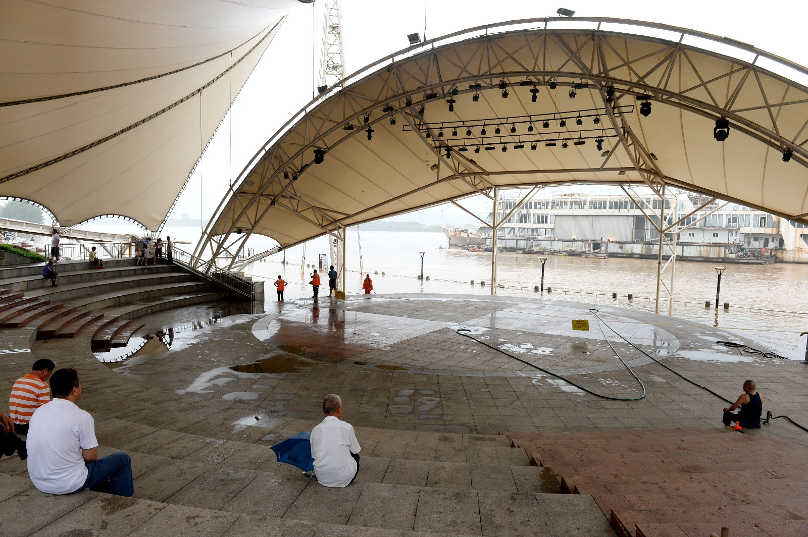 7月12日，湘江水位下降，环卫工人在开福区风帆广场及时清淤后，舞台恢复如常。