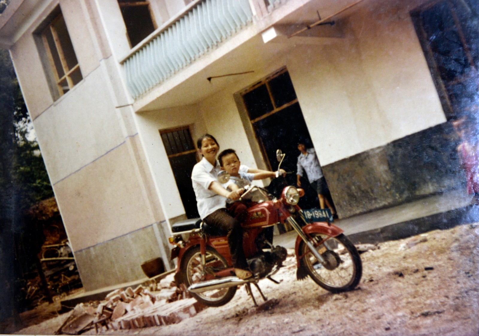 1986年，陈际平的儿子陈佳和妈妈在自家门前坐在摩托车上合影。长沙晚报全媒体记者 邹麟 翻拍