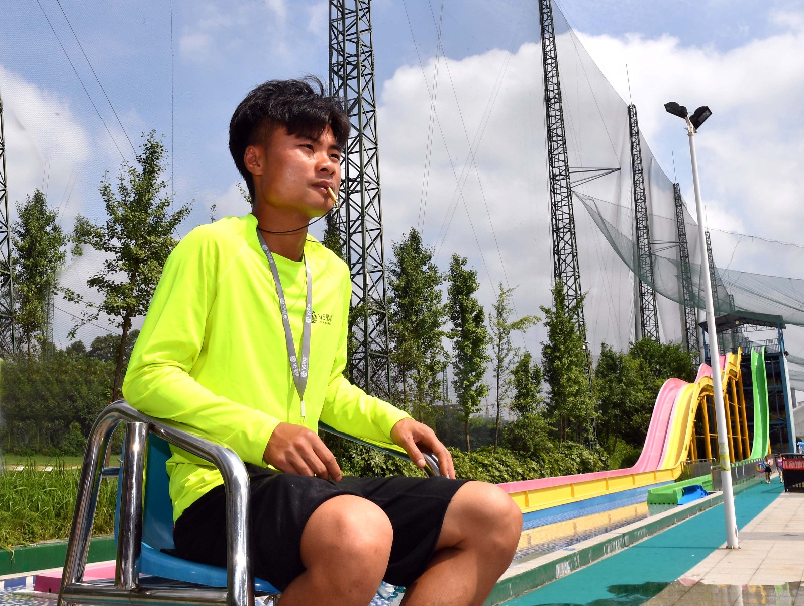 高温烈日下，吴林伟坐在高台上，正一丝不苟地观察着泳池中的一举一动。