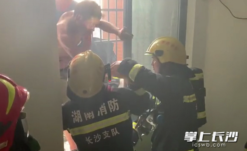 消防员将7楼窗户破开，先后将轩轩和彭先生救出。视频截图