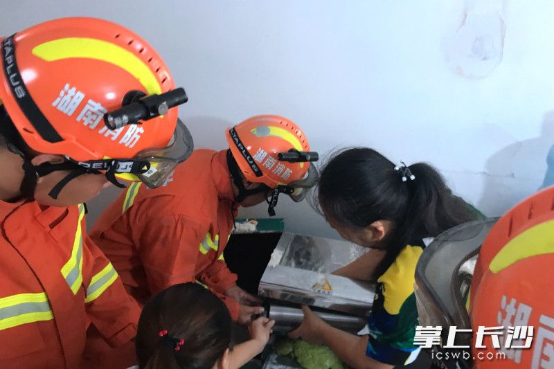 救援现场，消防救援人员对压面机进行拆解。宁乡消防供图