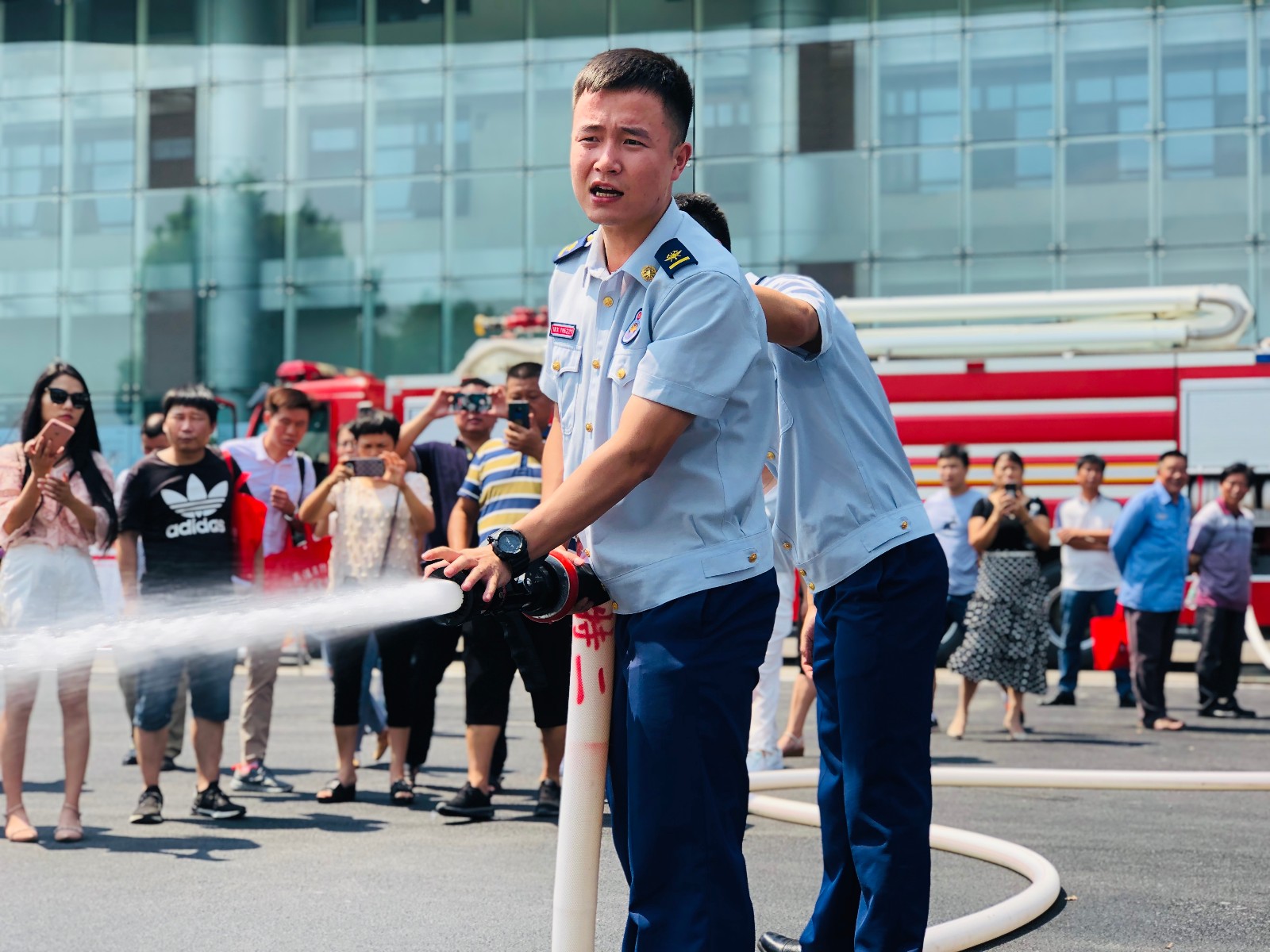 消防员现场示范消防水带的应急使用。 全媒体记者 李卓 摄