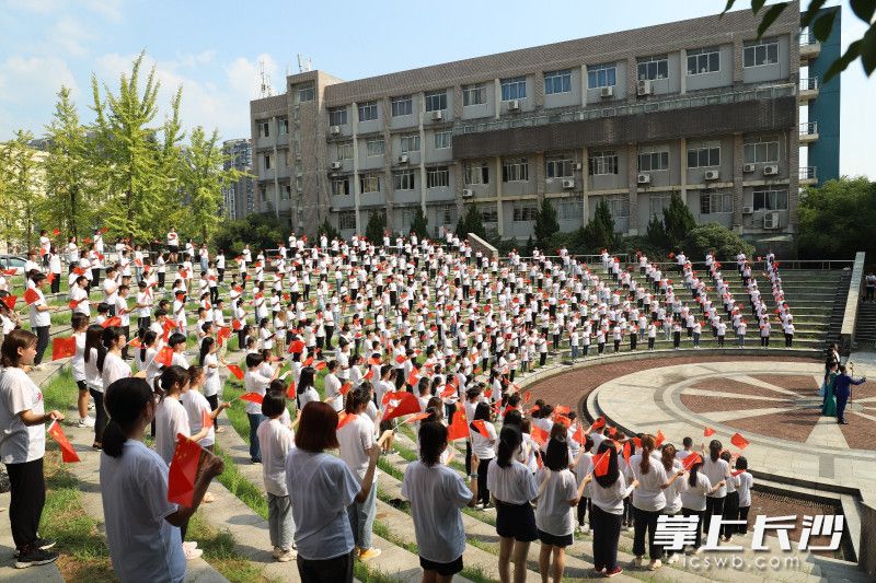 我爱你，中国!师生舞动手中的五星红旗。程思齐摄。