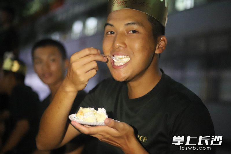 一名新兵吃蛋糕，庆祝“集体生日”。