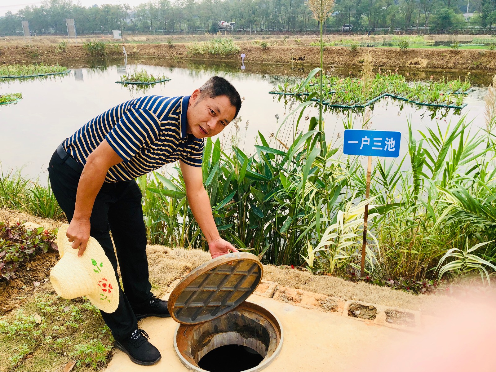 村民李金刚给记者展示“一户三池一湿地”的现场。 全媒体记者 李卓 摄