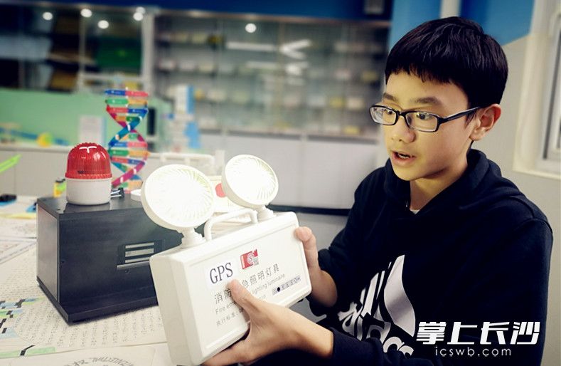 刘昕阳介绍他们获奖的可拆分式GPS消防应急灯发明作品。