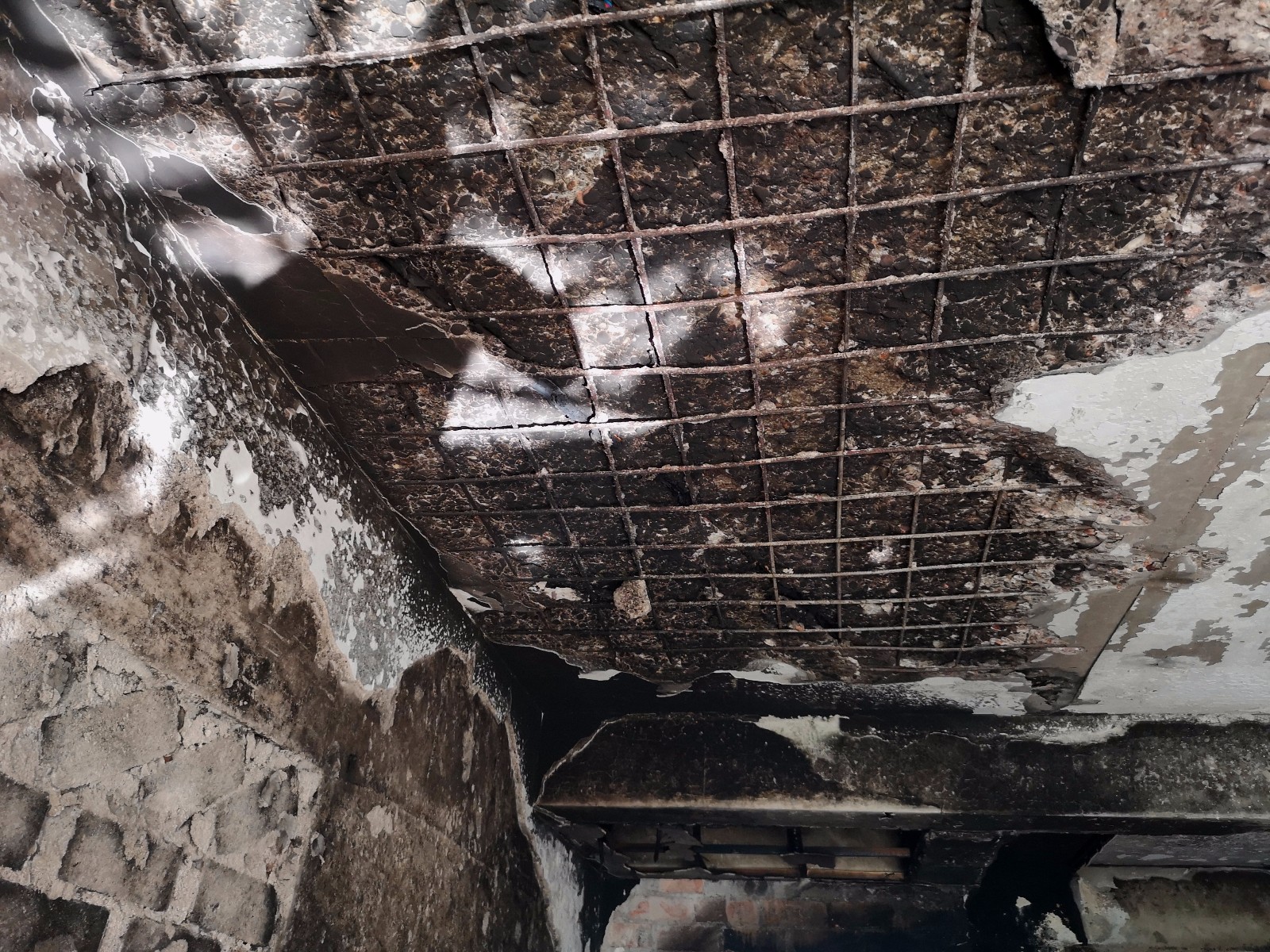 房顶的混凝土，被烧得露出了里面的钢筋骨架。
