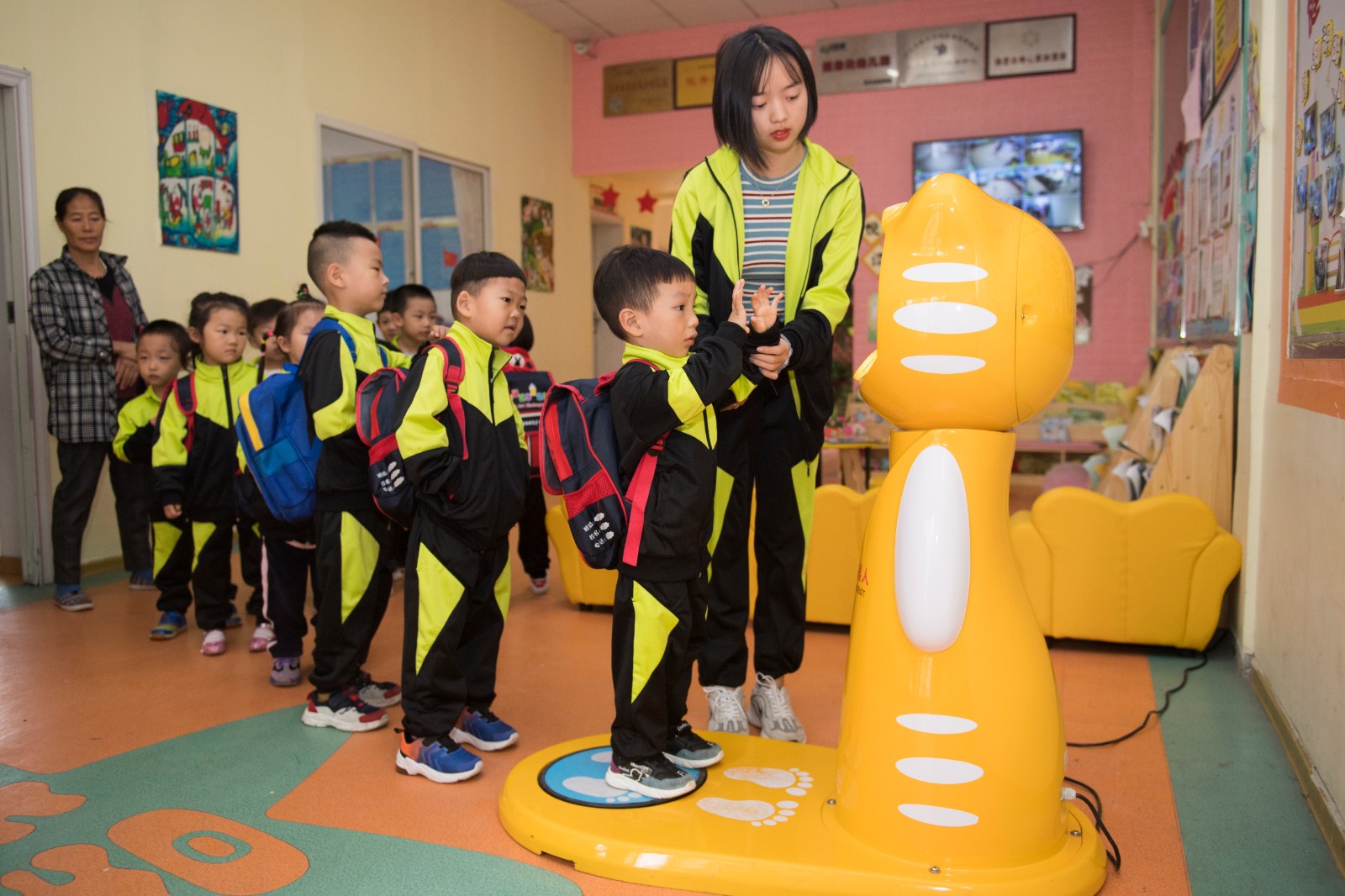 开福区华星幼儿园的孩子们正在排队做晨检，代替老师做这一工作的是一台萌萌哒的机器人。均为长沙晚报全媒体记者 黄启晴 摄