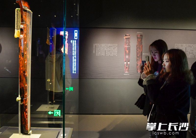 10月30日，湖南省博物馆潇湘古琴文化展展厅内古琴爱好者正在参观拍照。长沙晚报全媒体记者 邹麟 摄