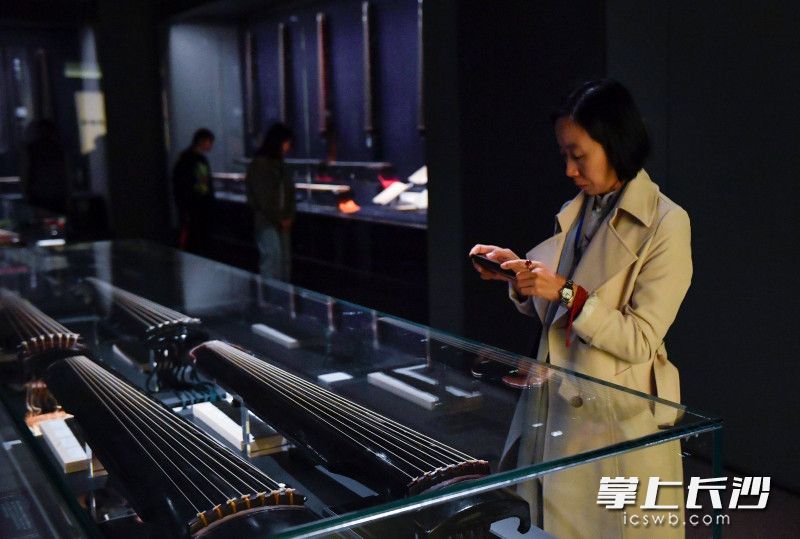 10月30日，湖南省博物馆潇湘古琴文化展展厅内一位古琴爱好者正在观展拍照。长沙晚报全媒体记者 邹麟 摄