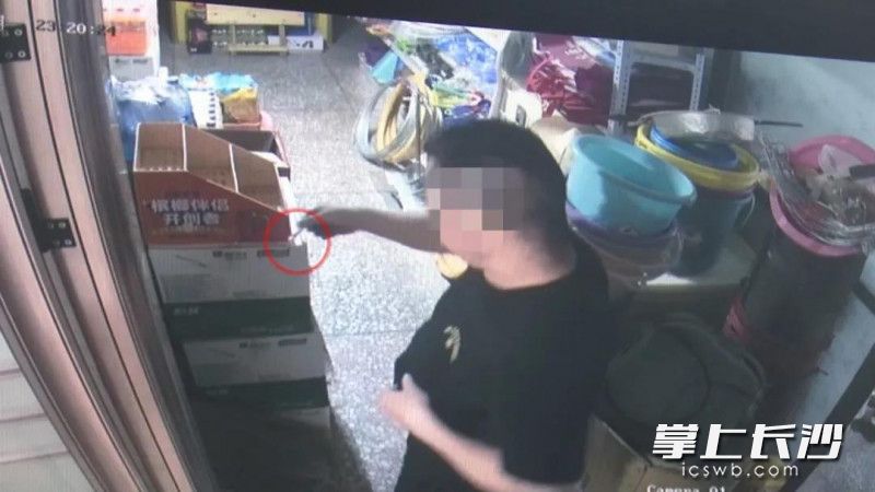 监控视频记录了超市男主人将烟头放在纸箱上的过程。