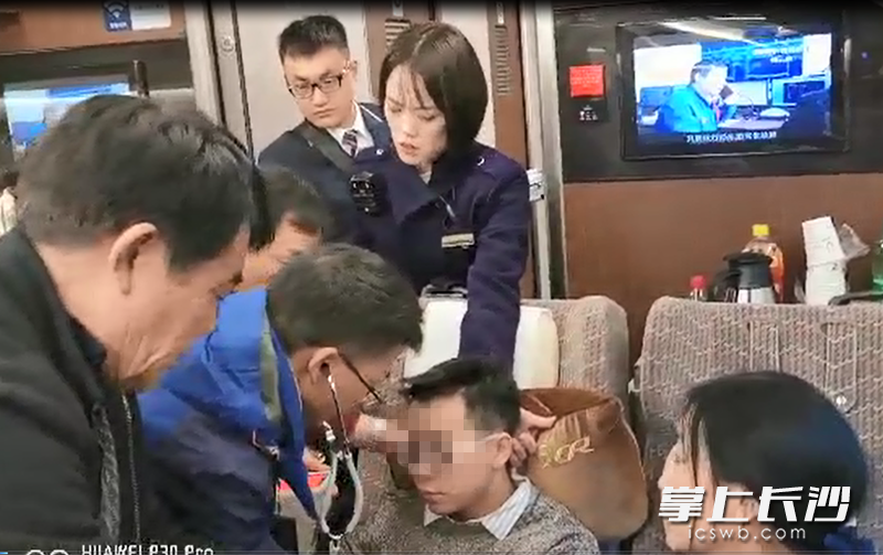 浏阳市人民医院心血管内科副主任谌承志（戴听诊器）和多名长沙医生一起在高铁上救治一名急症患者。 屏幕截图