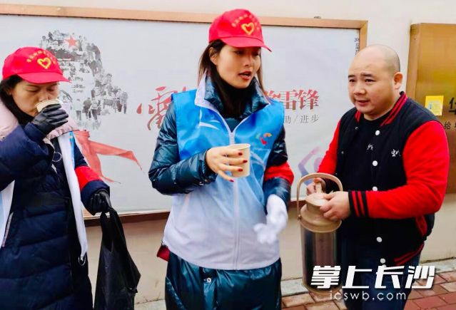 湖南好人吴鑫成（右一）给寒冬街头工作的环卫工、协管员以及志愿者送来热腾腾豆浆和早餐。 通讯员 范辉云 摄