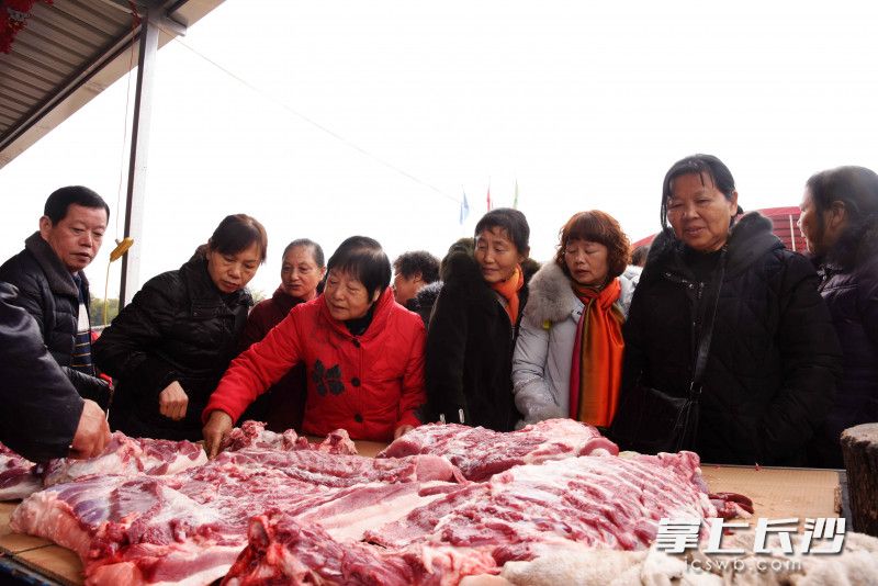游客现场选购猪肉等年货产品。