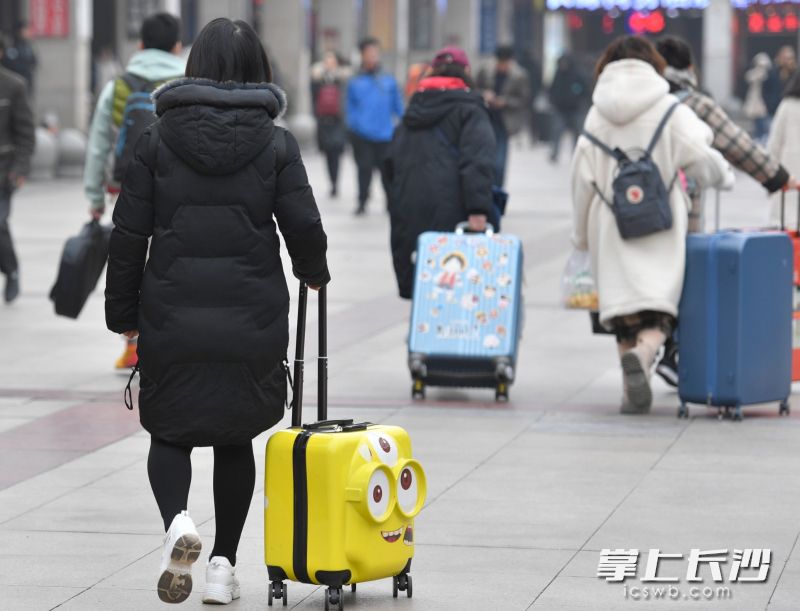 一位乘客推着一个小黄人模样的行李箱，格外亮眼。