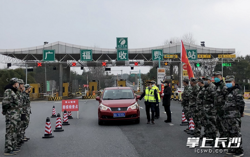 在长沙县广福收费站，民兵正在对过往车辆人员进行体温测量。