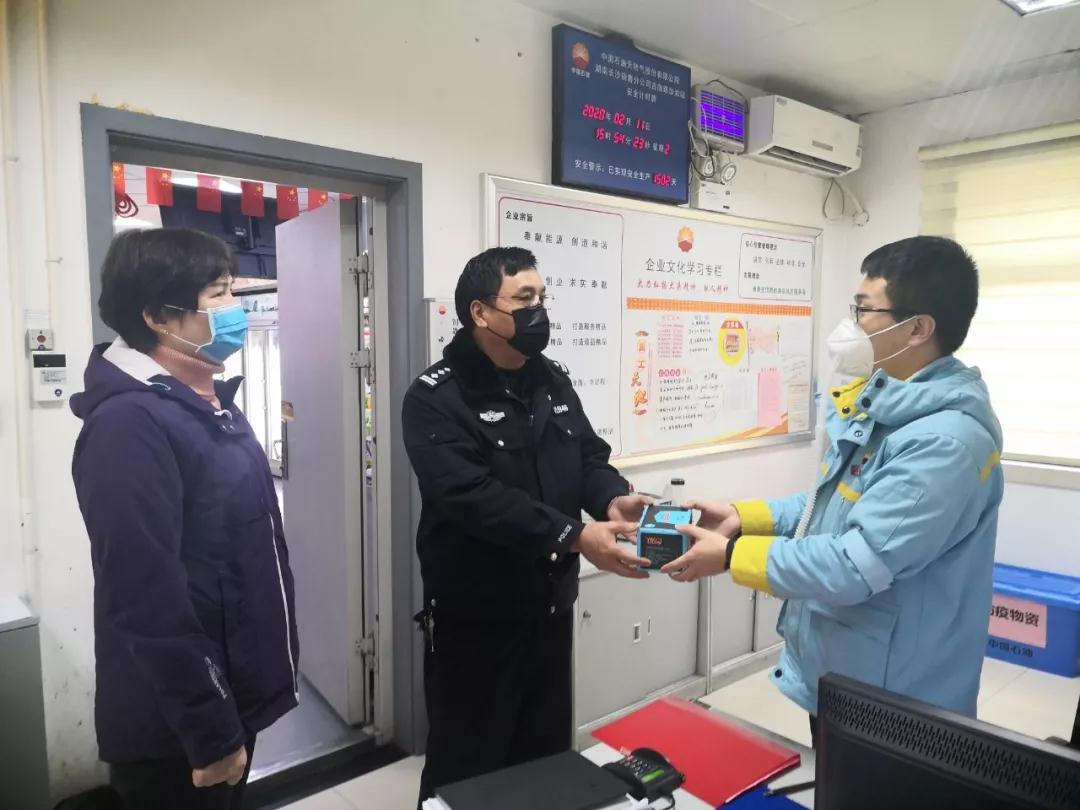 社区民警刘头仔将口罩交到加油站负责人手中。芙蓉警方供图