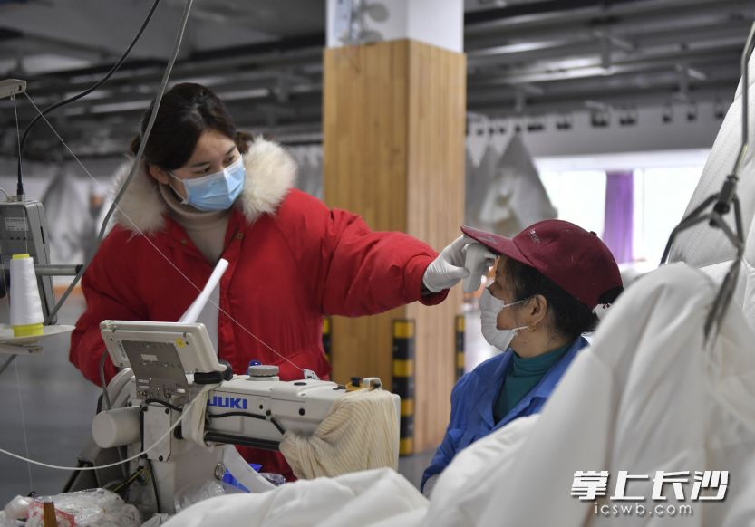梦洁家纺生产车间，工人们戴着口罩正在有序工作，定时测量体温。