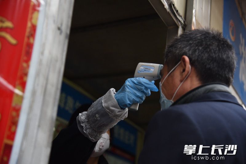 17路公交车驾驶员彭炳华上车前，接受体温检测。