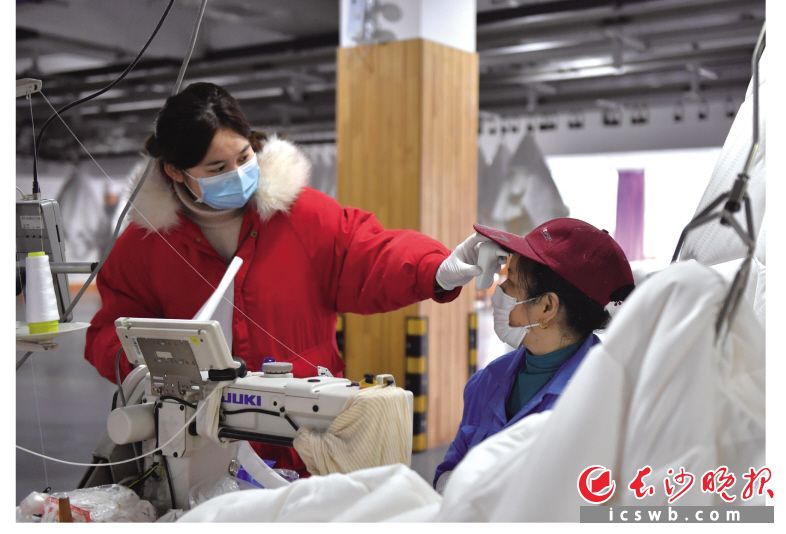 梦洁家纺生产车间，工人们戴着口罩有序工作。