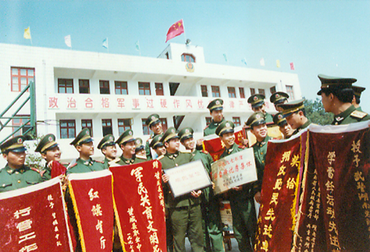 上个世纪90年代，中队官兵看着中队一面面奖牌锦旗，脸上露出喜悦的笑容。