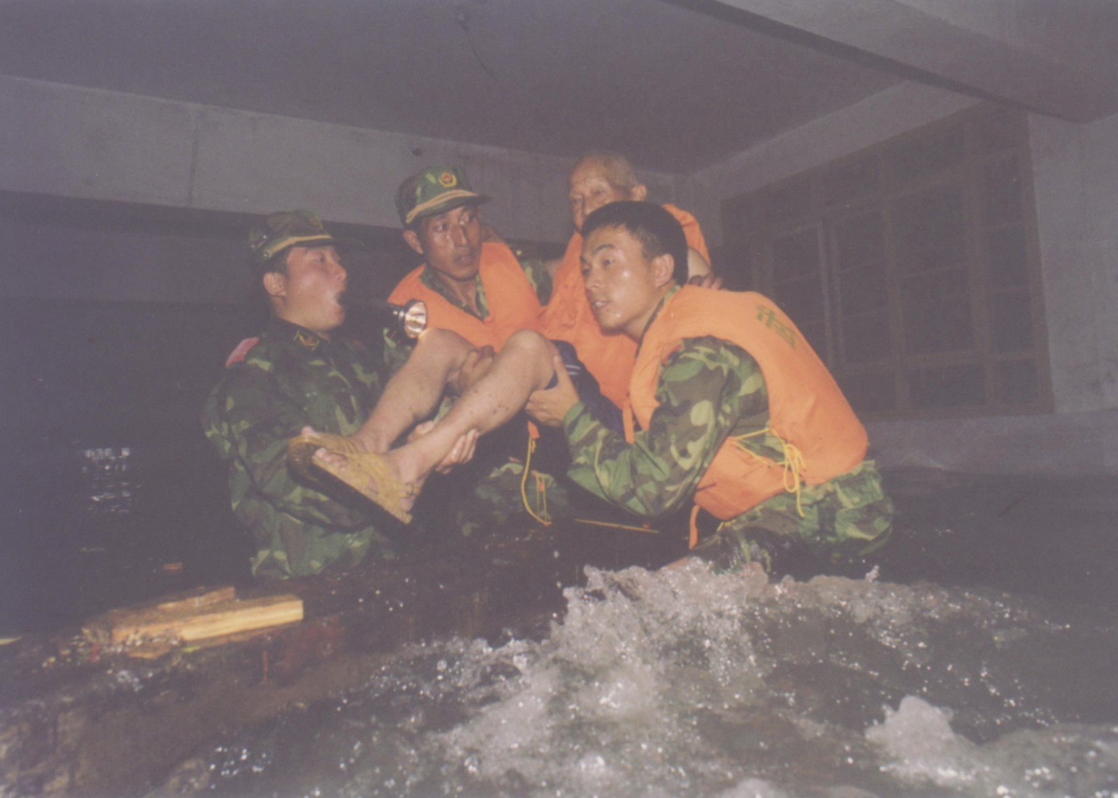 1998年抗洪场景，中队官兵不畏艰险，救助驻地群众。