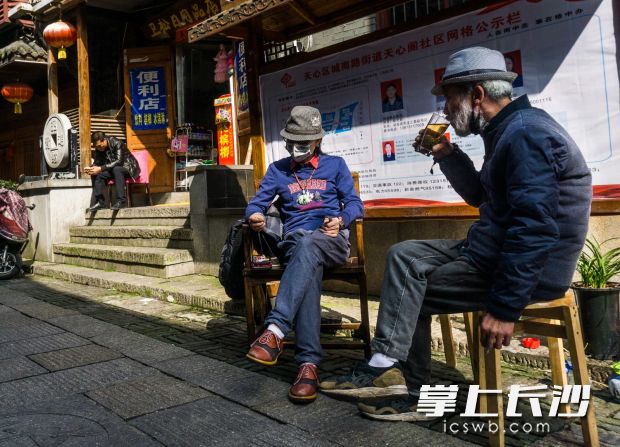 在天心区县正街，两位老长沙聊天喝茶晒太阳，惬意无比。  彭福宗  摄