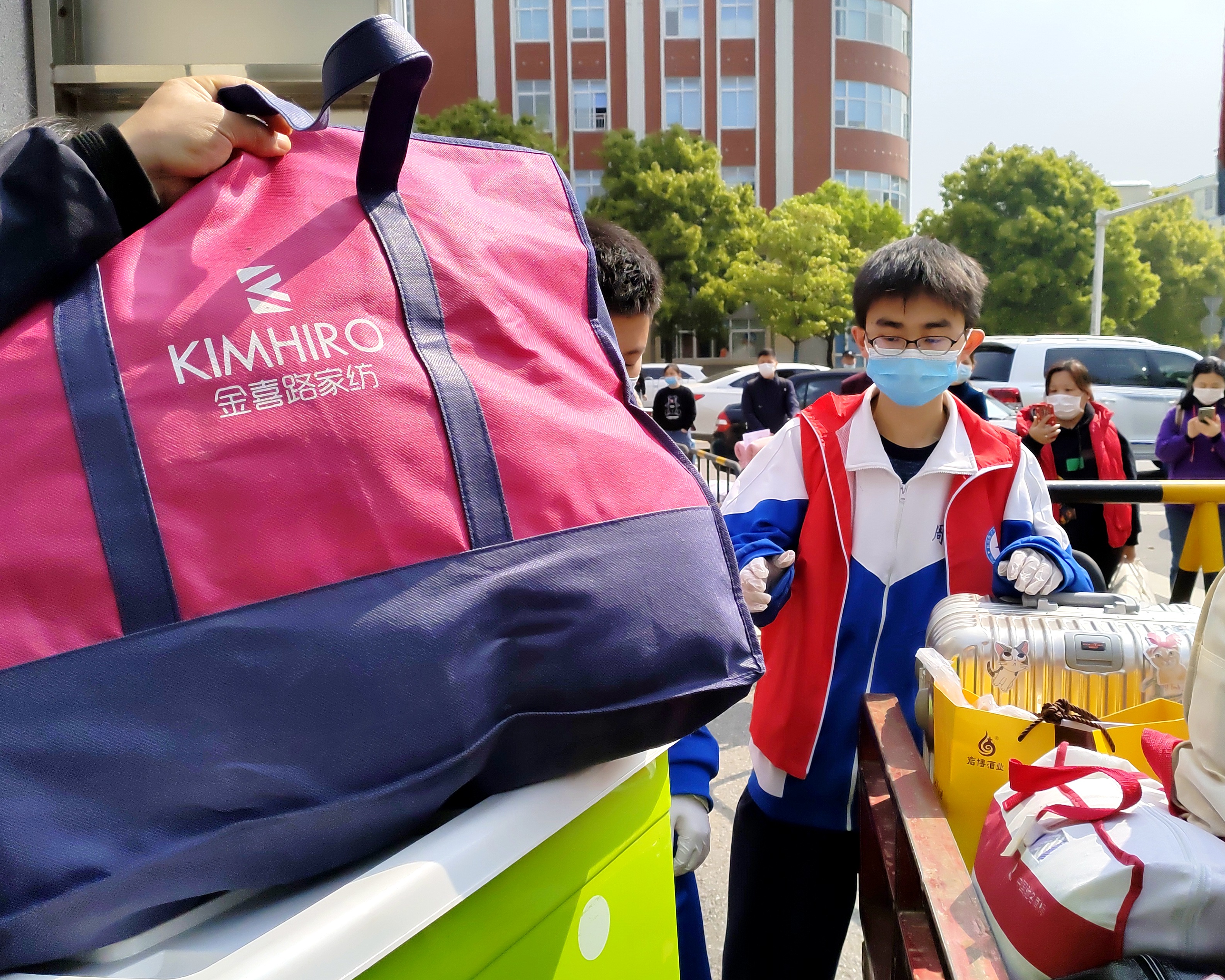 周南中学学生志愿者为同学搬运行李，助力复学防疫。