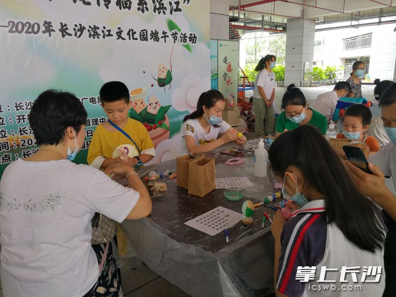 6月25日，“艾叶飘香迎端午，红绳传福系滨江”端午节手工活动在长沙滨江文化园环岛举行。