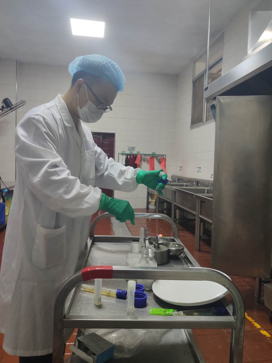 何清彦在对明德中学餐具抽样，以进行大肠杆菌项目的检测。长沙晚报全媒体记者  周辉霞摄