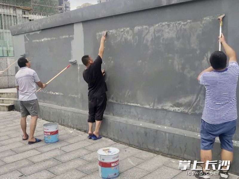清除破损广告、重新粉刷墙面，为韶山路沿线“洗脸打粉”。