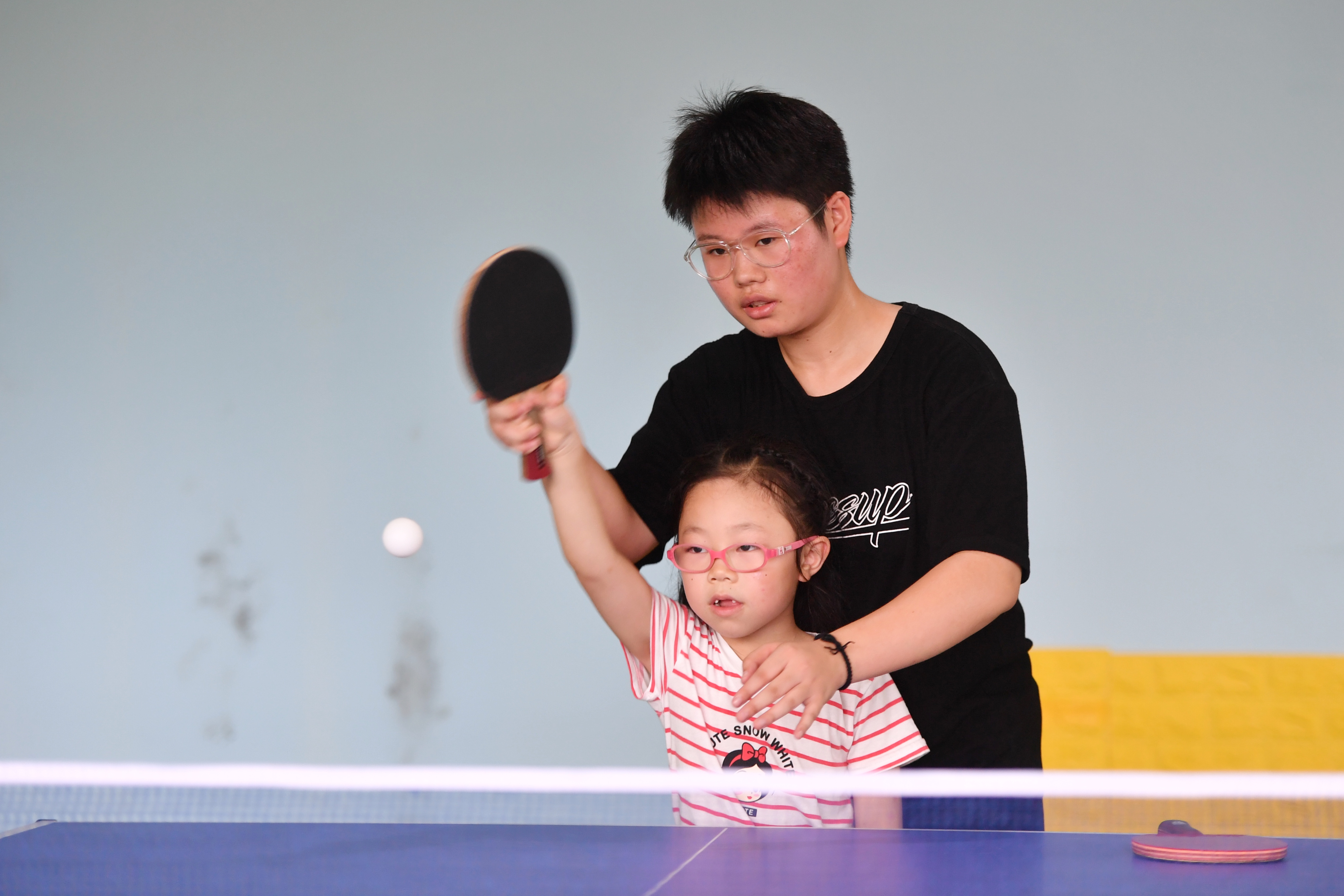 7月20日，星沙全民健身中心内，孩子们在教练的指导下进行乒乓球练习。