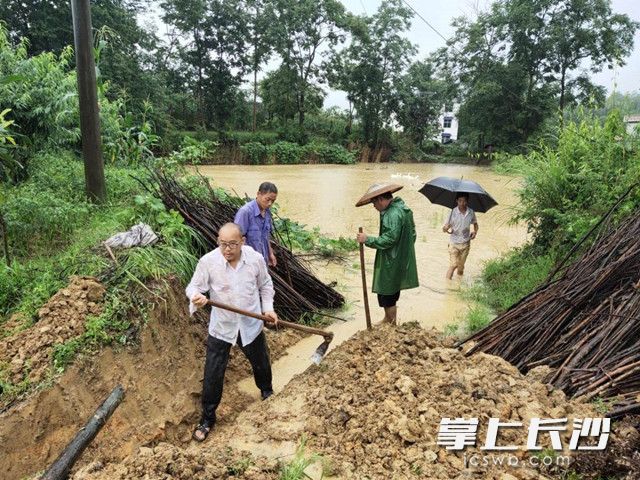 中信银行长沙分行驻村工作队和乡村干部对出现险情的山塘及时进行排查和疏浚。