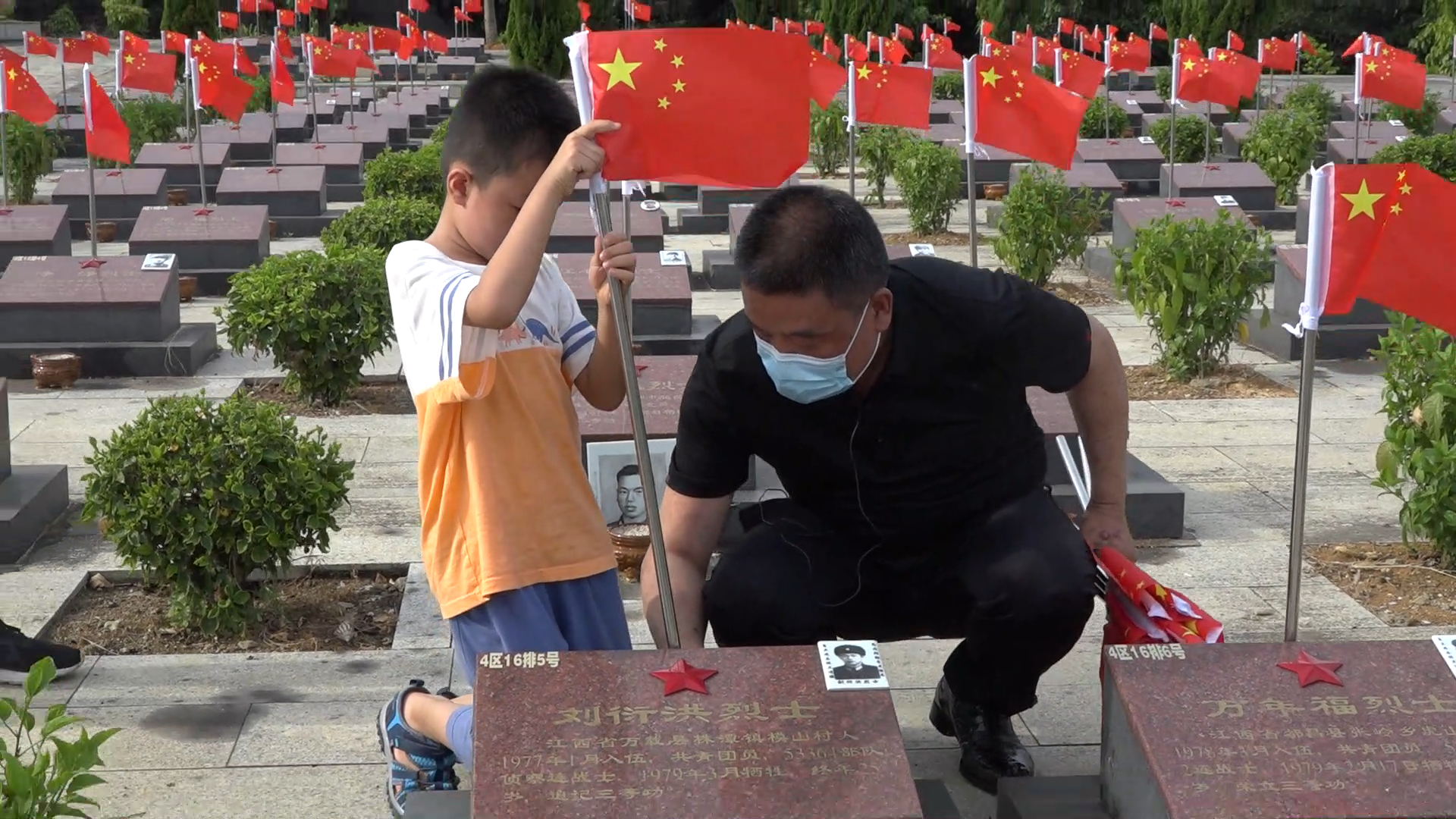 朱豫刚和一名年仅5岁的小小志愿者一道为烈士墓插上国旗。 图片均为长沙晚报通讯员 卢鹏 摄