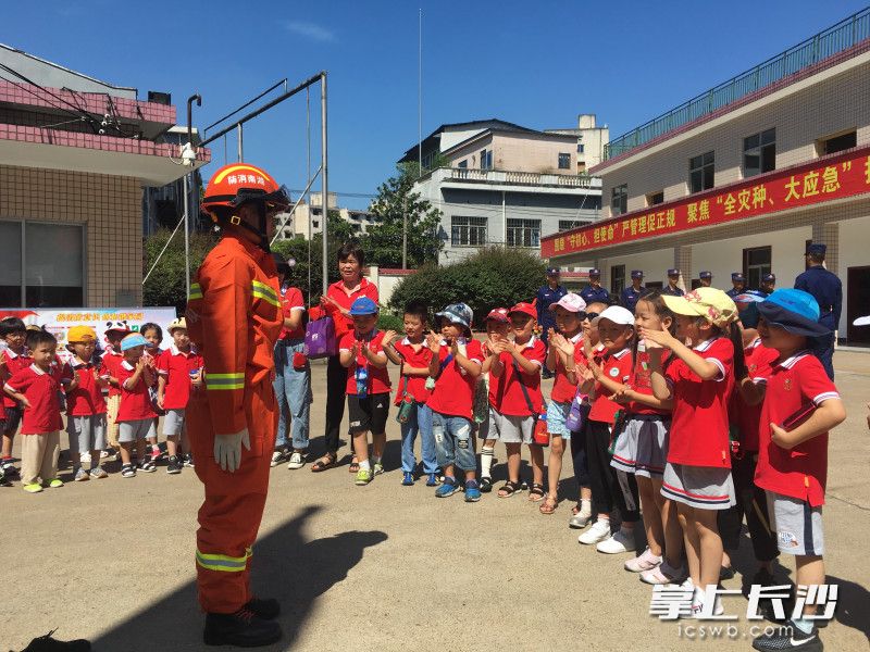 消防员为孩子们表演队列动作，赢来阵阵掌声。