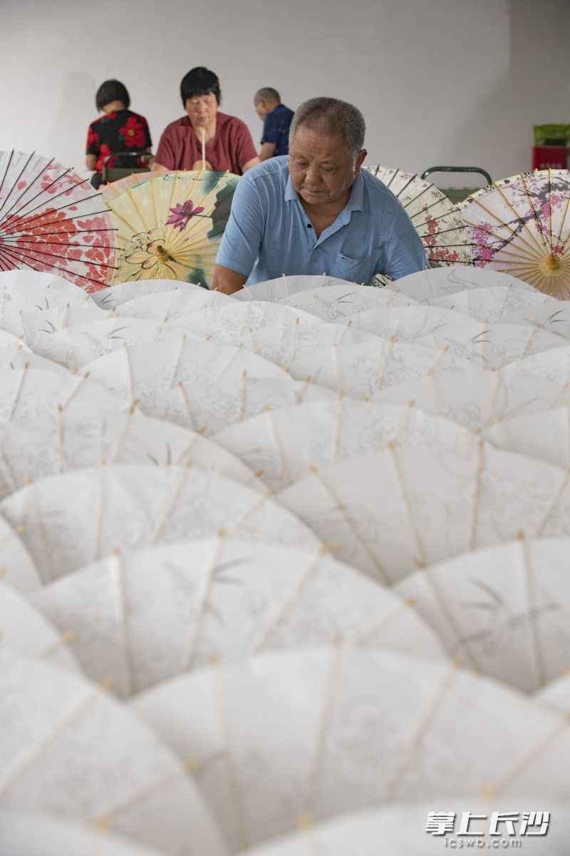 李忠国通过多年尝试，大大简化了工艺流程，每位村民只需掌握3个环节就能上工。廖尚凡夫妇一起每天能制作近100把大油纸伞。