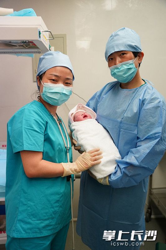 湖南援塞医疗队员黎江和武科怀抱着新生宝宝留影。
