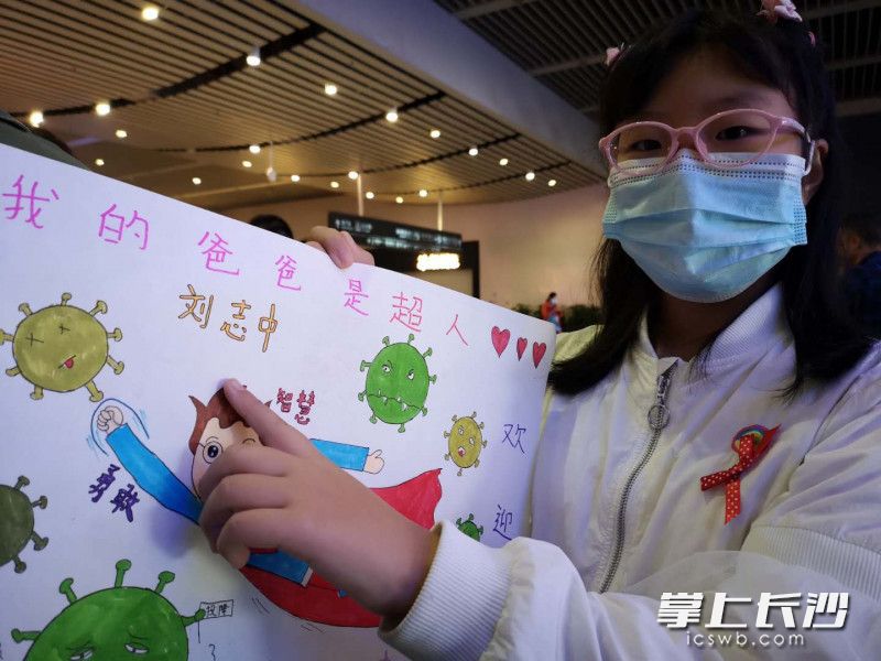队员刘志中的大女儿刘诗苗手捧着自己画的画，她说：“这是准备送给爸爸的见面礼。”