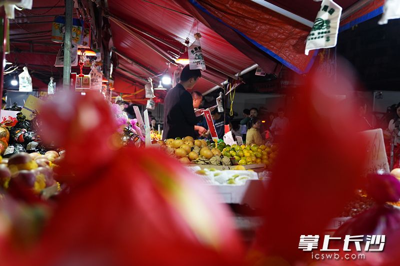 批发市场对面的水果摊贩。全媒体记者柳静芸摄