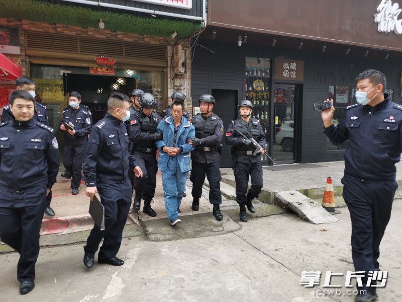 张承禹在警察的押送下走出当年作案现场 警方供图