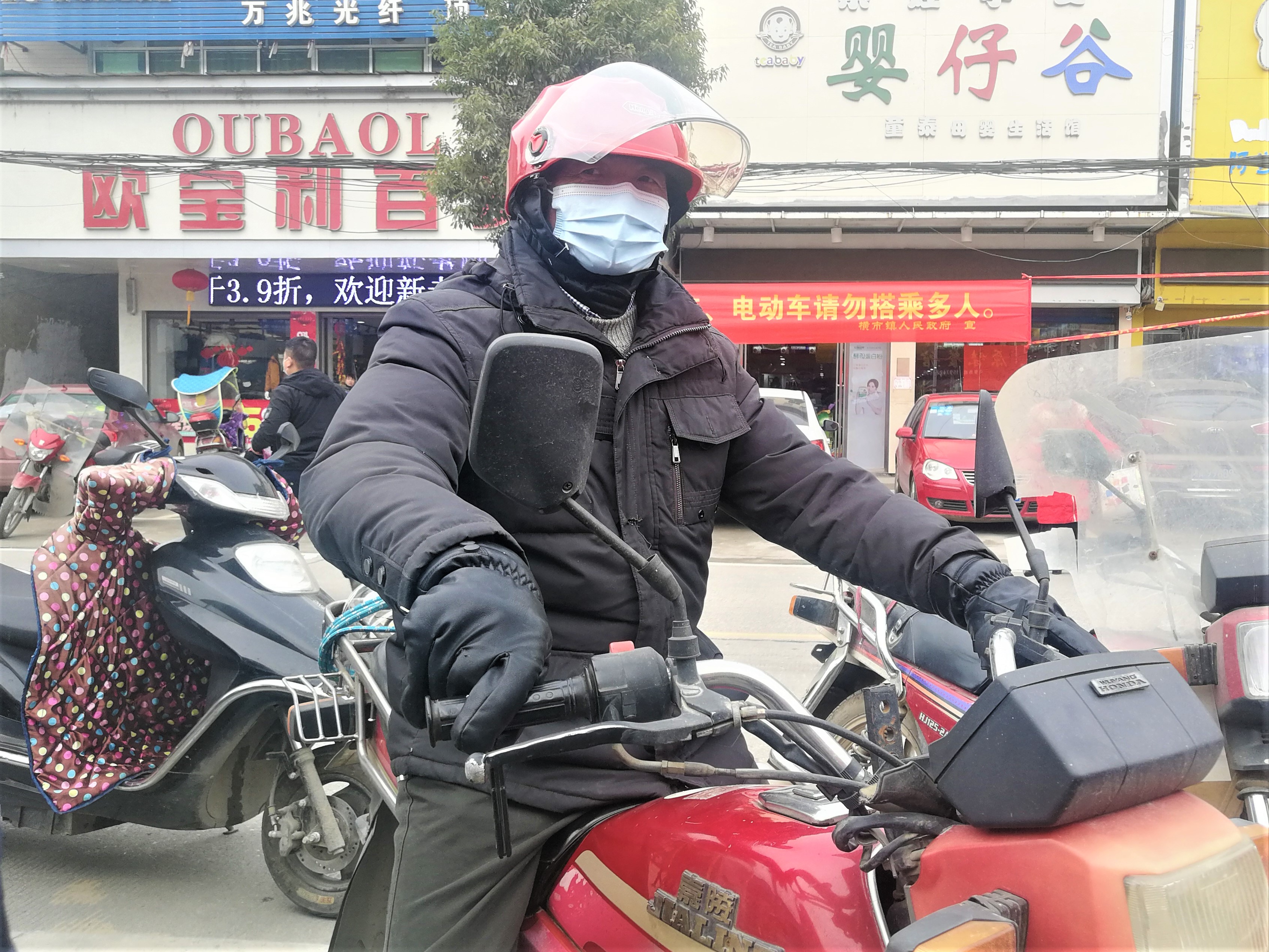 64岁的秦桂良是横市镇云山村村民，他十分开心地戴上免费领取的红色摩托车头盔。长沙晚报全媒体记者 张禹 摄