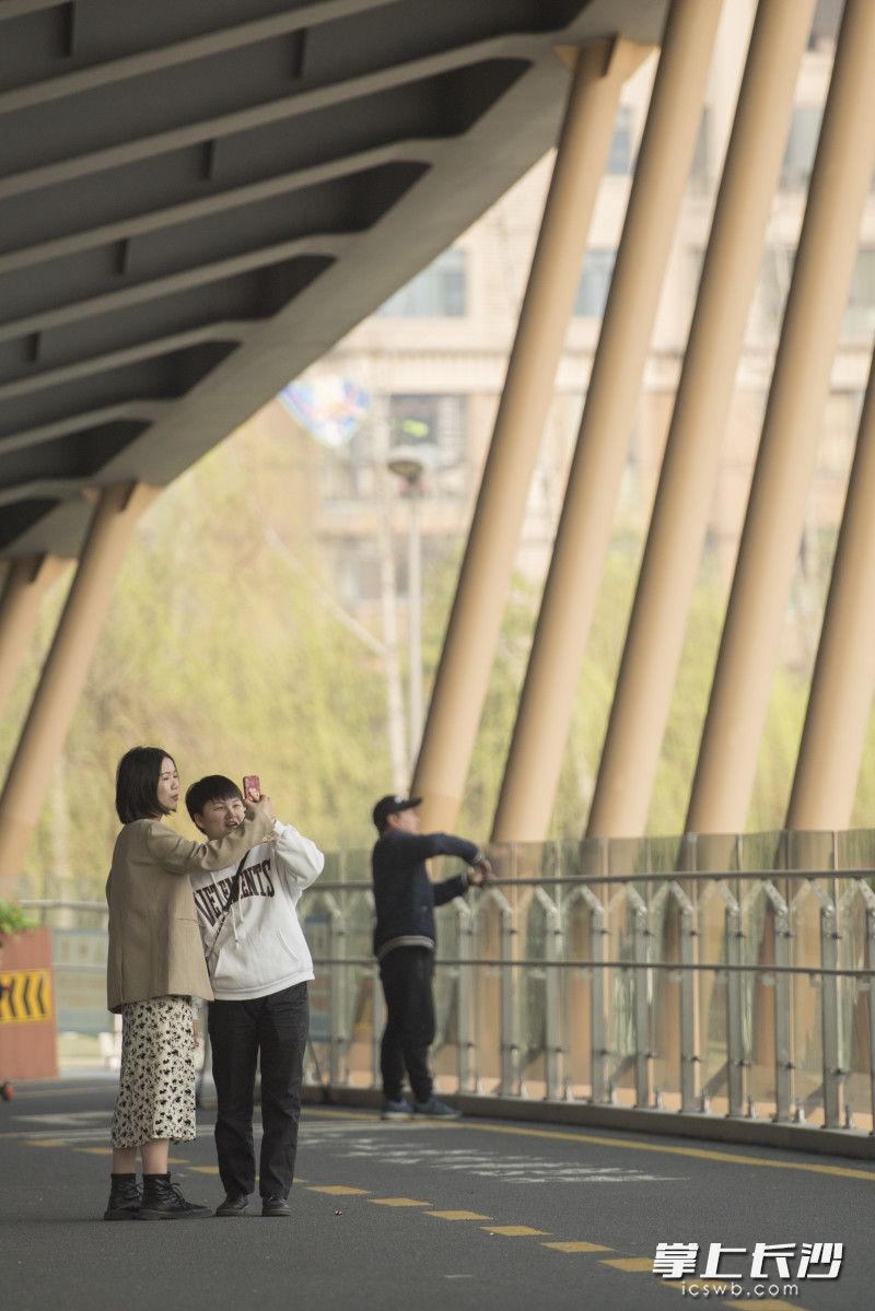 在附近工作的杨小姐趁着工作闲暇，就和朋友一起来汉桥打卡拍照了。“这个桥的结构太适合拍照了。”