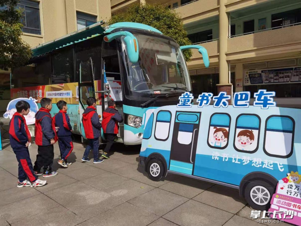 孩子们轮流登上童书大巴车借阅图书。全媒体记者 朱华摄
