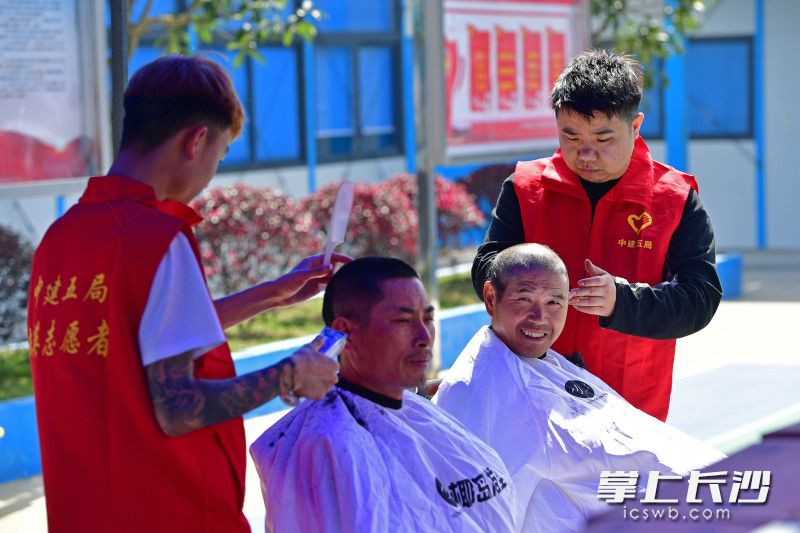 志愿者们用娴熟利落的手艺，很快剪出一个个干净利落的发型，让连日来无暇打理头发的工人瞬间精神了不少。