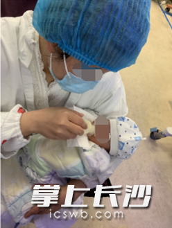 经护士指导，“轮椅妈妈”在准备进行母乳喂养。