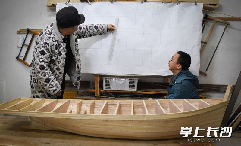 刘罗三和儿子刘军一起看图纸，根据图纸反复比较。