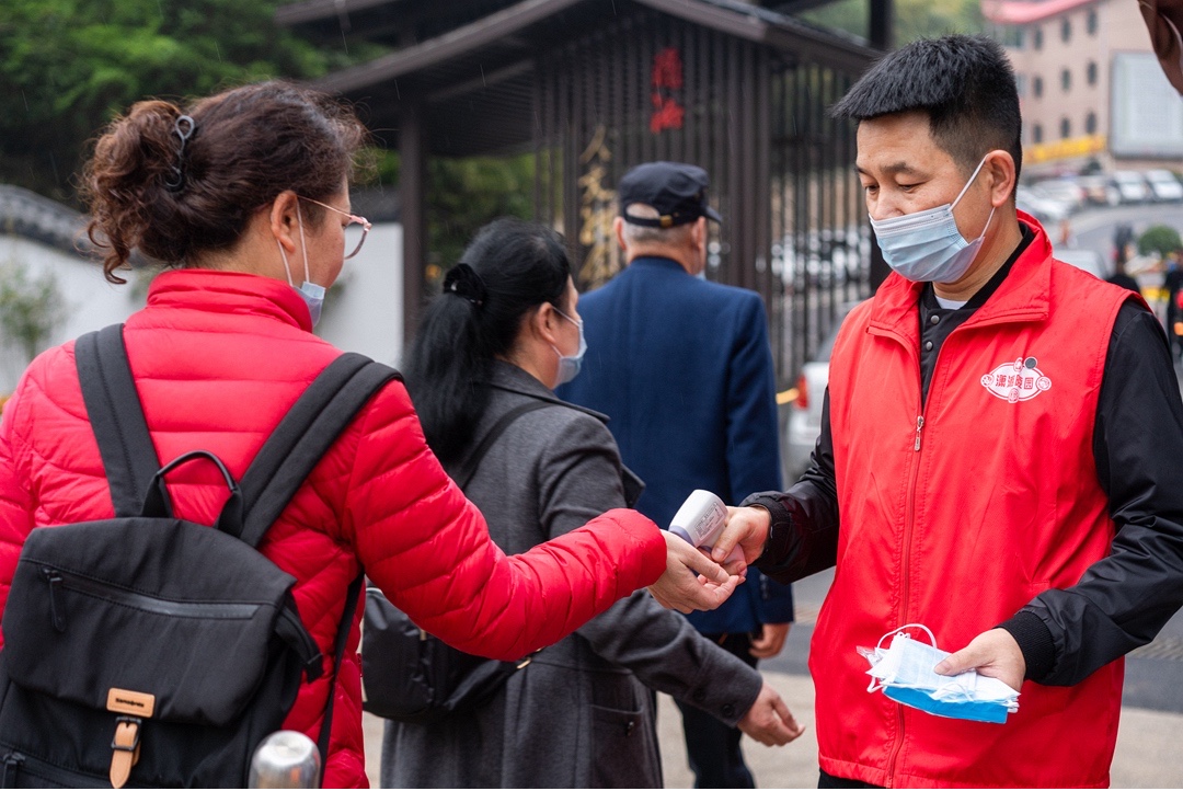 在长沙潇湘陵园入口，前来祭扫的市民群众主动配合墓园疫情防控出示预约二维码、测量体温等。长沙晚报通讯员 朱江 摄