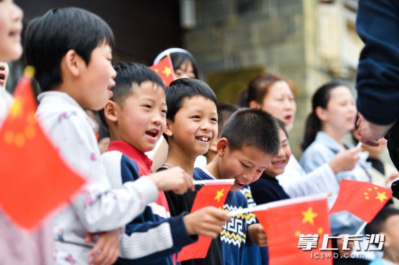 孩子们挥舞着国旗跟随着音乐的节拍一起合唱。