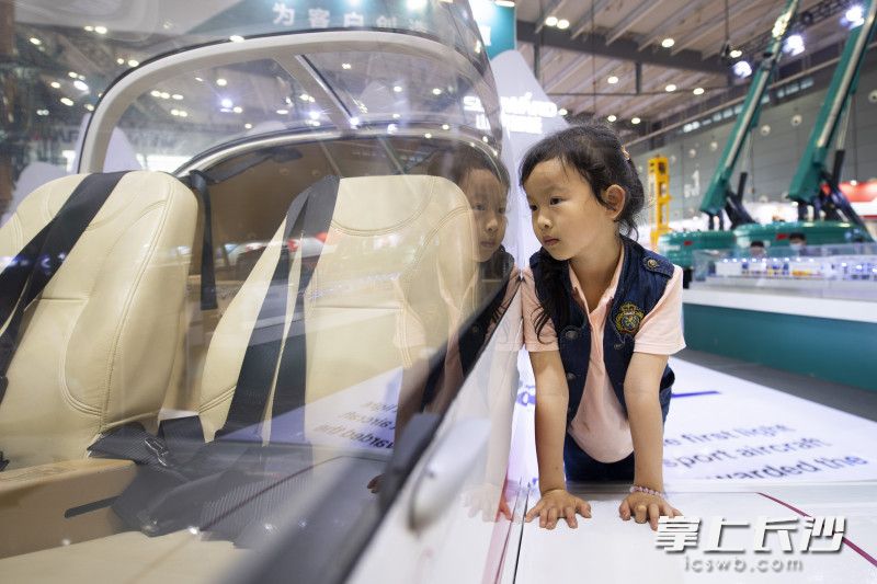在山河智能的展台前，一位小朋友在看着飞机驾驶室。